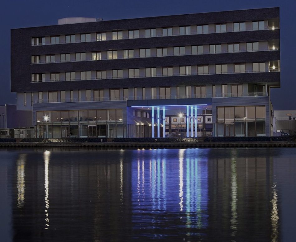 Kantoorgebouw aan het water in de avondschemering